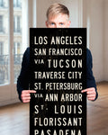 Man holding a custom subway sign in a room.