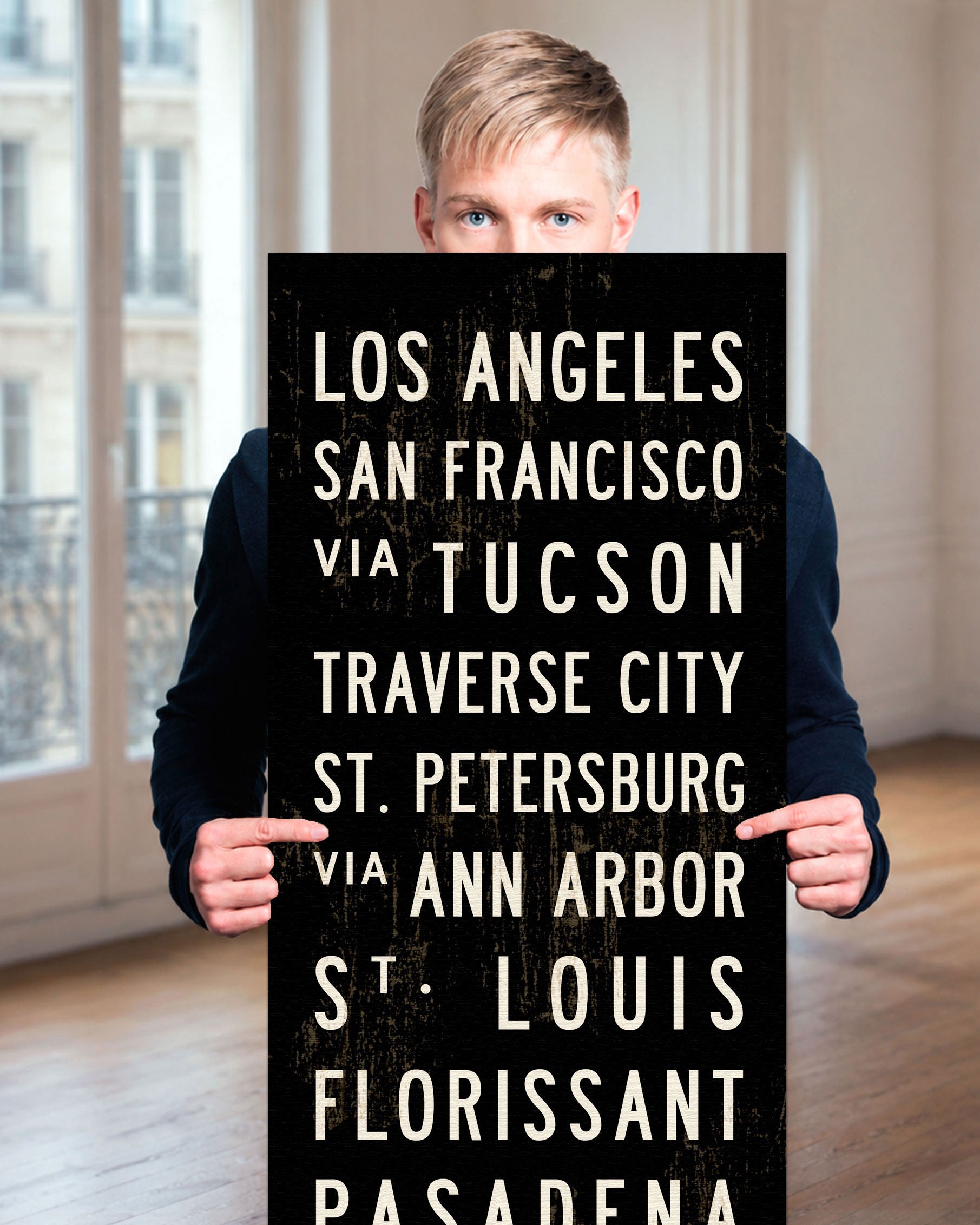 Man holding a custom subway sign in a room.