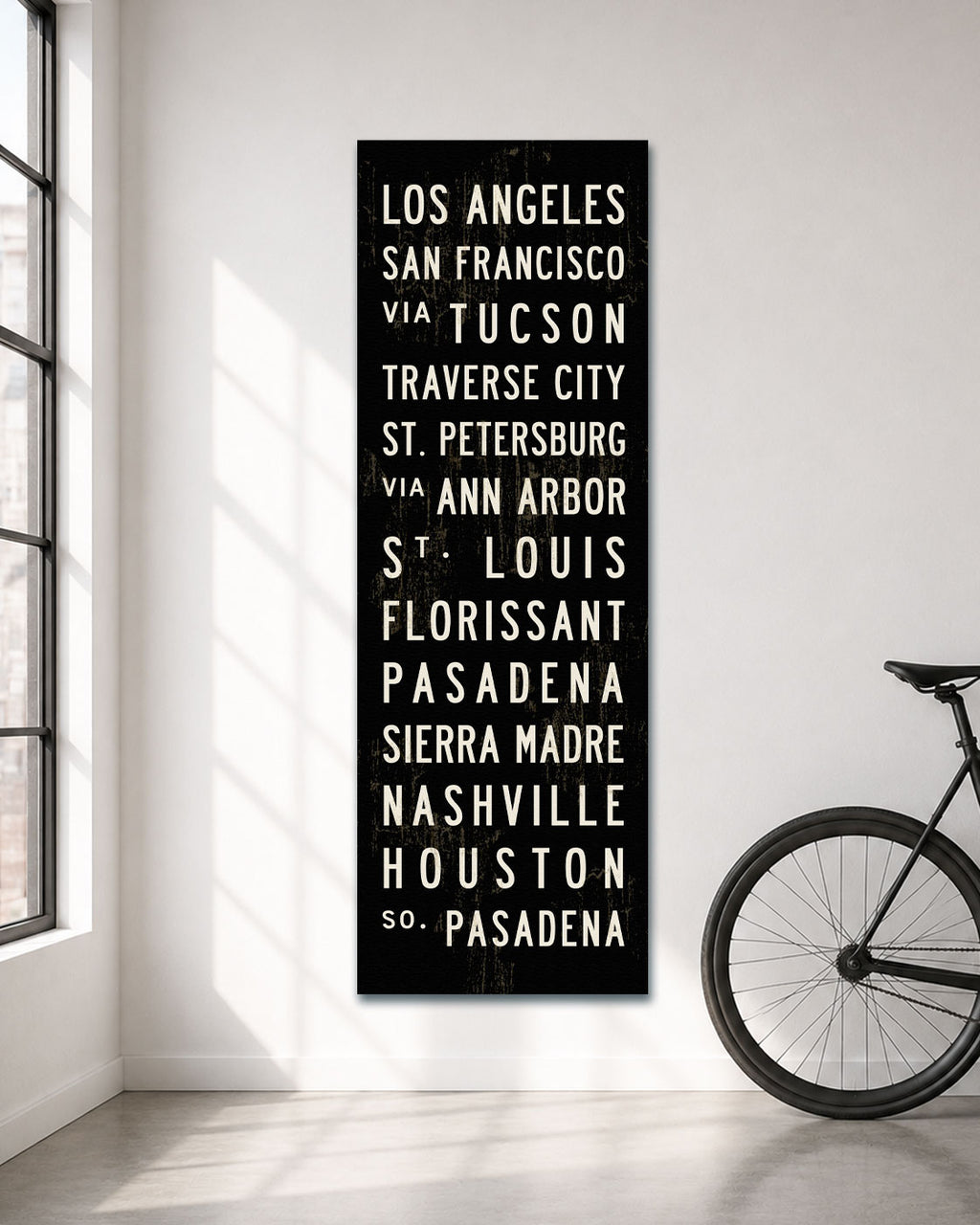 Custom Subway Sign canvas art hanging in a white room with a bicycle standing next to it.