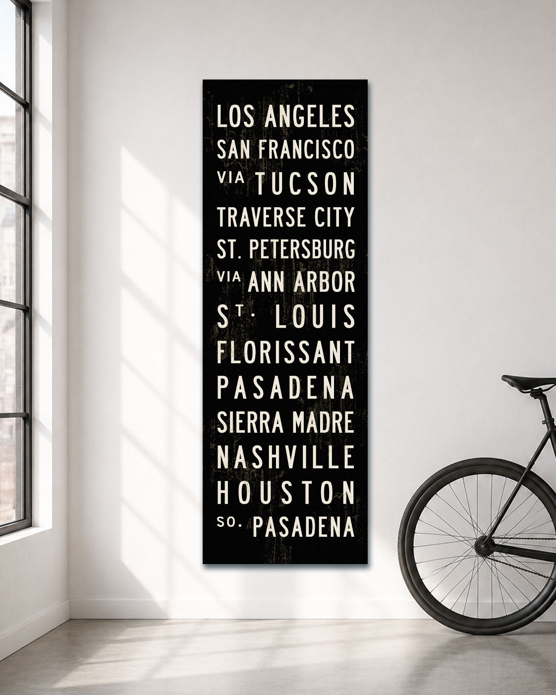 Custom Subway Sign canvas art hanging in a white room with a bicycle standing next to it.