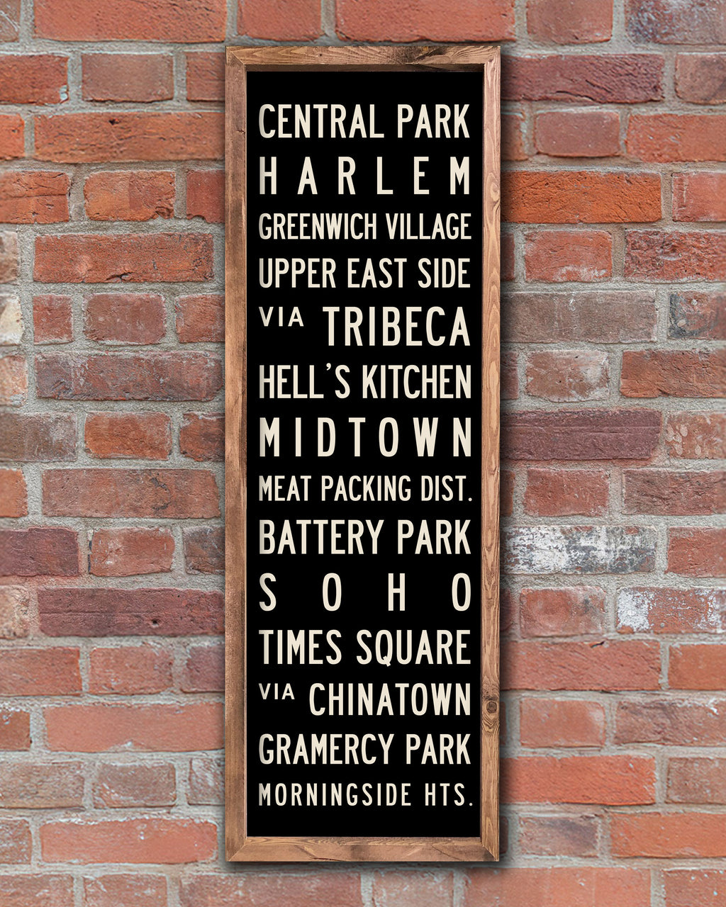 Wood New York Subway Sign Art hanging on a red brick wall