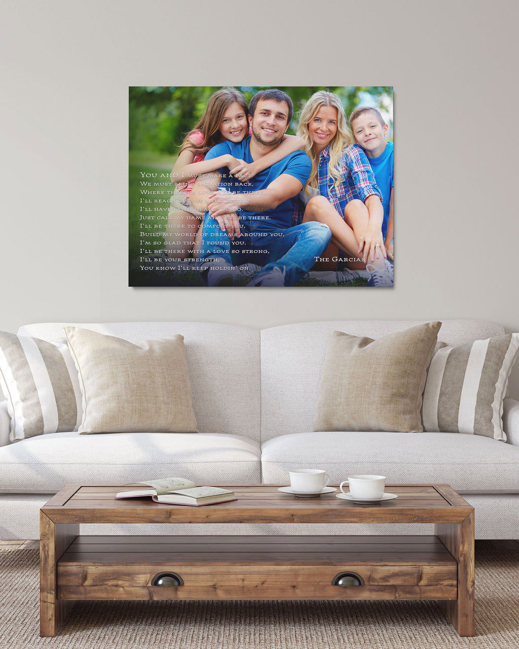 A framed custom family photo canvas print with a poem overlay, displayed on a light gray wall above a beige sofa in a living room setting