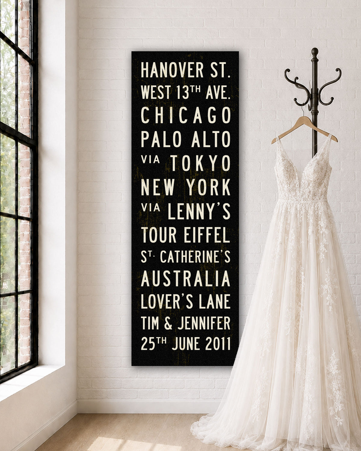 Personalized Wedding Subway Sign hanging on a wall with wedding dress on hanger next to it.
